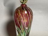 a glass vase with a red and green design on it