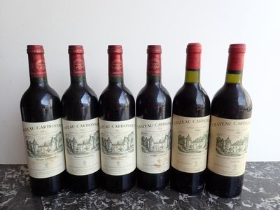 six bottles of wine are lined up on a table