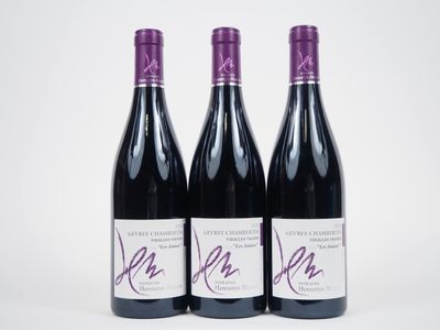 trois bouteilles de vin sont posées sur une surface blanche