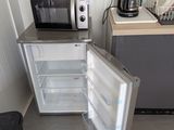 un réfrigérateur ouvert et un micro-ondes dans une petite pièce
