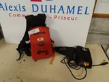 un sac à dos rouge posé sur une table à côté d'un panneau indiquant « Alexis Duhamel, lauréat du prix Comm »