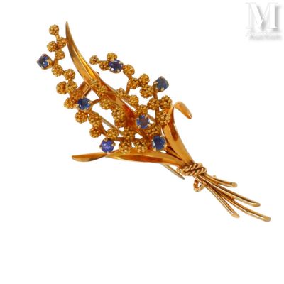 une image représentant une broche en or ornée de pierres bleues