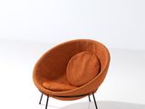 an orange chair with black legs and a round cushion on a white surface