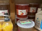 bottles of juice and juices are on a shelf in a kitchen