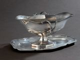 une assiette en argent sur laquelle est posée une soucoupe en argent