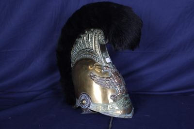 un casque doré orné d'une plume noire