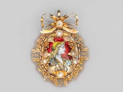 une image représentant une broche en or ornée d'un oiseau et de fleurs