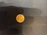 a gold coin sitting on top of a black table next to a window