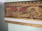 a gold and red decoration on the wall of a room