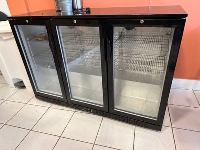 deux réfrigérateurs à portes vitrées posés sur un sol carrelé
