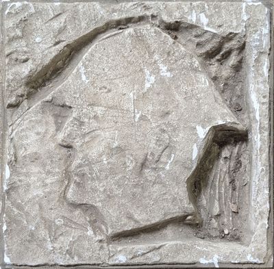 une sculpture en pierre représentant la tête d'un homme sur un mur