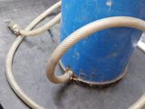 a blue barrel with a hose attached to it