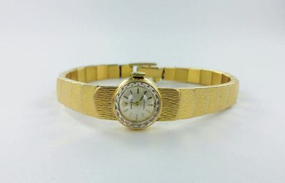 une photo d'une montre pour femme montée sur un bracelet en or
