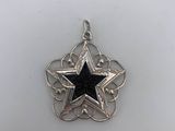 a silver and black star pendant on a white background