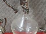 un pichet en verre et une assiette en argent posés sur une table rouge