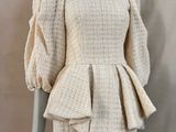 une photo d'un mannequin portant une robe blanche à manches longues