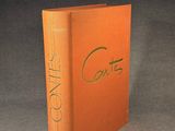 an orange book sitting on top of a table next to a black background
