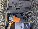 a tool in a case on the ground next to the grass