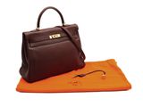 a brown leather handbag sitting on top of an orange towel