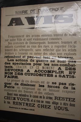 une affiche accrochée au mur d'un immeuble sur laquelle est écrit un poème en français
