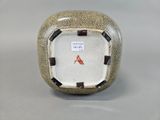 a small square shaped vase with a brown and white design
