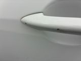 the door handle of a white car with a black spot on it