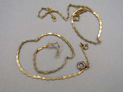 trois bijoux en or posés sur une table