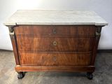 an antique chest of drawers with marble top on casteors