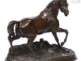 bronze statue of a horse running on a rocky surface