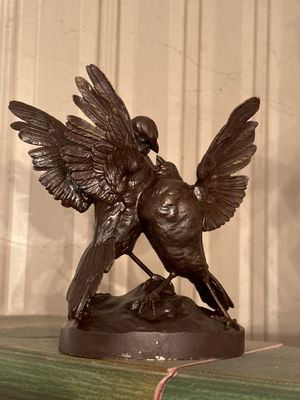 une statue représentant un oiseau perché sur un livre