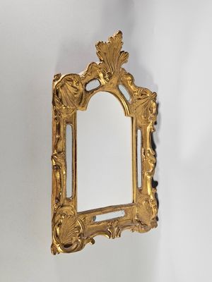 un miroir doré accroché au mur d'une pièce