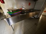 a stainless steel sink in a kitchen with a metal counter top