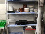 a metal shelf with dishes on it in a kitchen