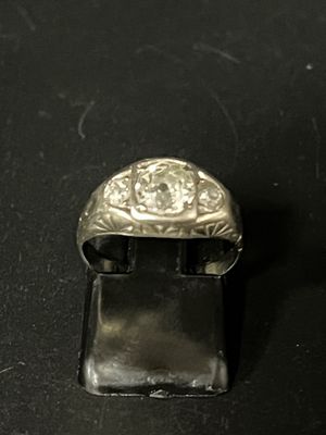 une bague en argent sertie d'un diamant, posée sur une surface noire