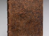 un vieux livre à la couverture brune posé sur une table