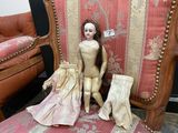 a doll that is sitting on a chair next to a chair