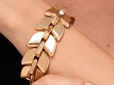 une femme portant un bracelet en or orné d'un motif de feuille