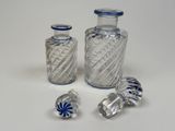 three glass bottles with blue and white designs on them