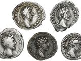 four ancient roman coins, one of which has a head of a woman and one of which has a crown