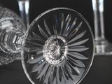 three wine glasses sitting on a table with a black background