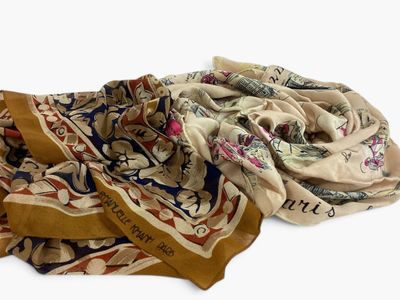 several different colored scarves are laid out on a white surface