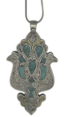 a close up of a silver and turquoise pendant on a chain