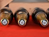 several bottles of wine are lined up on a red cloth