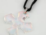 un pendentif en forme de croix en verre, monté sur un cordon noir