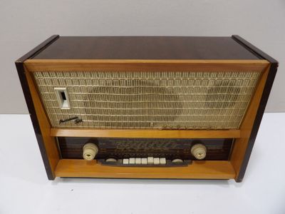 une radio à l'ancienne posée sur une table blanche