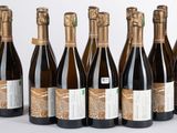 six bouteilles de vin alignées sur une surface blanche