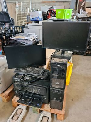 un tas de matériel informatique posé sur une palette dans un entrepôt