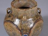 a brown vase with a blue stone in it