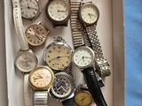beaucoup de montres dans une boîte posée sur la table