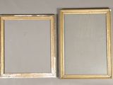 two gold picture frames on the wall next to each other